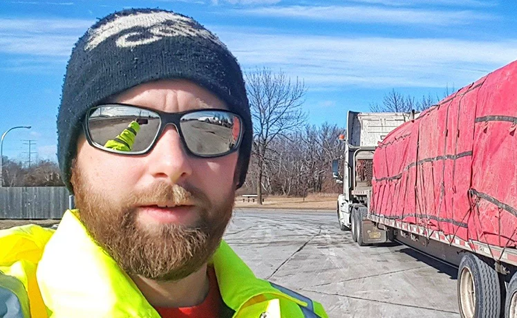 Close up of Trucker Josh's face with a diesel semi truck in the background